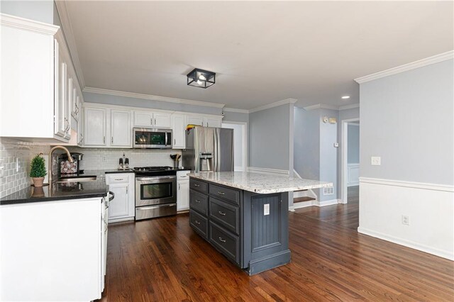kitchen featuring stainless steel appliances, white cabinetry, and a sink