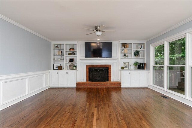 unfurnished living room featuring visible vents, built in features, a fireplace, dark wood-type flooring, and a ceiling fan