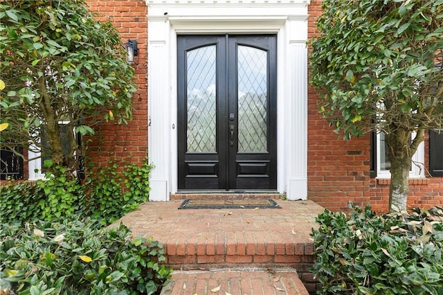 property entrance featuring french doors and brick siding
