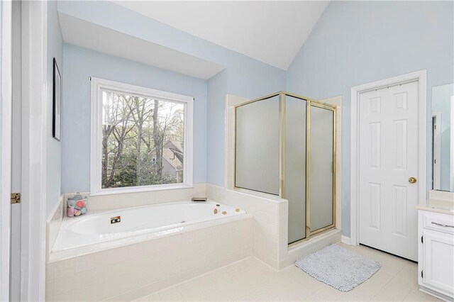 bathroom with tile patterned flooring, vanity, a bath, a shower stall, and vaulted ceiling