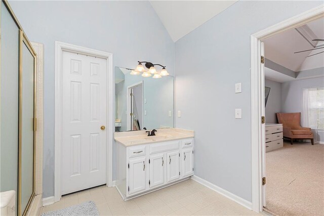 full bathroom with vaulted ceiling, a stall shower, vanity, baseboards, and connected bathroom