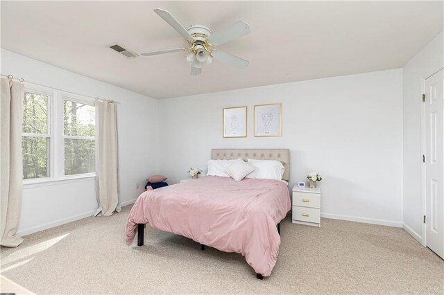 carpeted bedroom featuring baseboards, ceiling fan, and visible vents