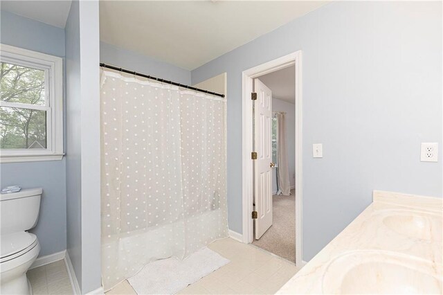 full bathroom featuring a sink, baseboards, toilet, and double vanity