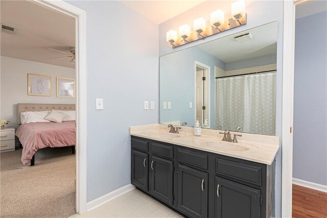 bathroom featuring a sink, baseboards, ceiling fan, and visible vents