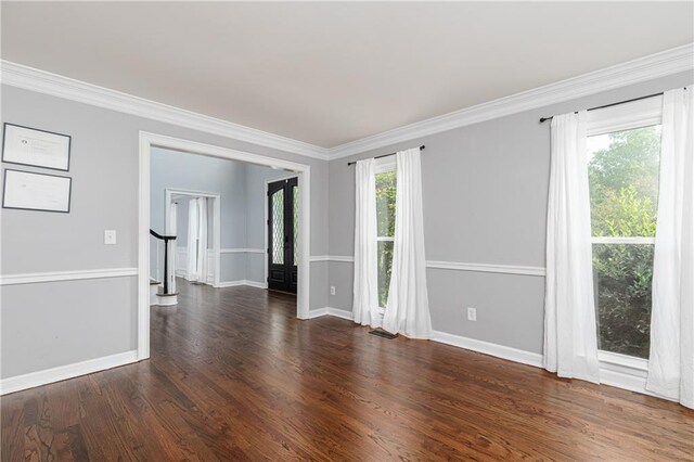 unfurnished room with baseboards, ornamental molding, stairs, and wood finished floors