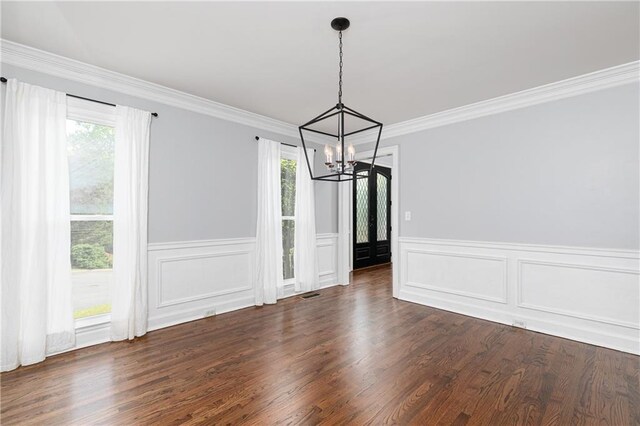 unfurnished dining area with an inviting chandelier, a wainscoted wall, dark wood-style floors, and visible vents