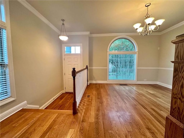 4875 Carre Way, Alpharetta, GA 30022 - foyer featuring plenty of natural light, a chandelier, baseboards, wood finished floors, and crown molding