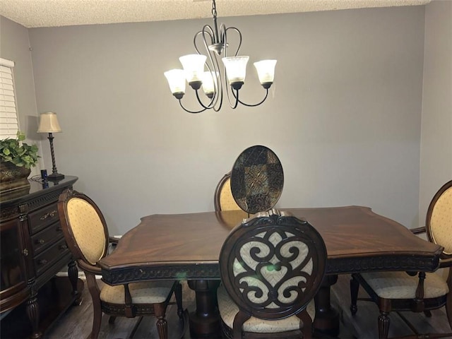 dining area with a chandelier, a textured ceiling, and dark wood-style floors