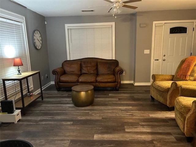 living area featuring wood finished floors, visible vents, a ceiling fan, and baseboards