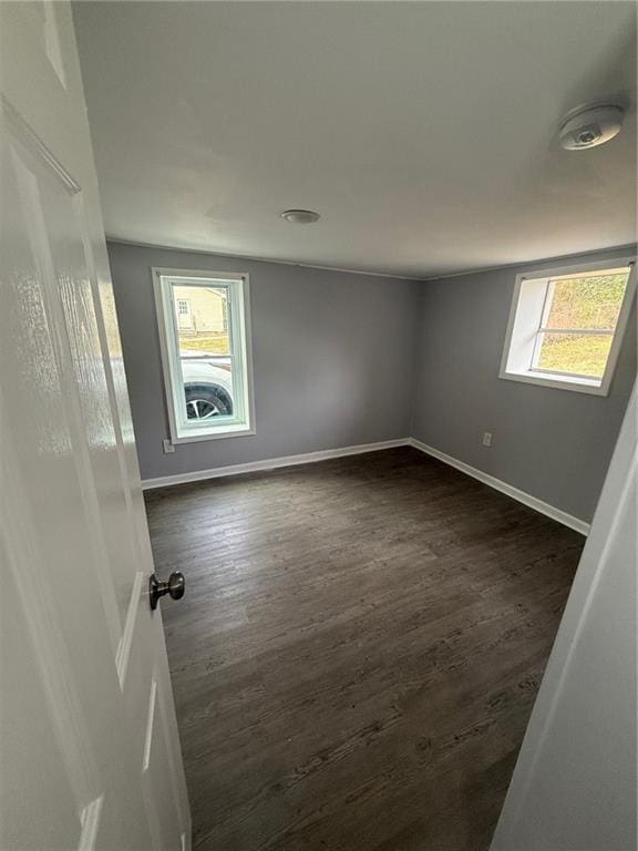 spare room featuring plenty of natural light and dark hardwood / wood-style floors