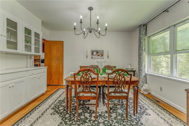 103 White Cir, Rockmart, GA 30153 - dining area with light wood finished floors, a chandelier, and baseboards