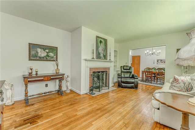 103 White Cir, Rockmart, GA 30153 - living area with a brick fireplace, a chandelier, light wood-style flooring, and baseboards