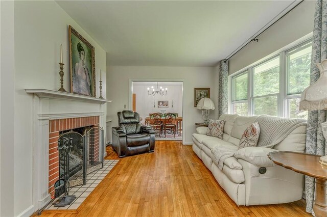 103 White Cir, Rockmart, GA 30153 - living area with a chandelier, light wood-style flooring, and a brick fireplace