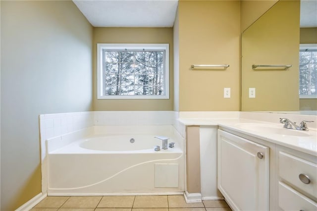 bathroom with tile patterned flooring, vanity, baseboards, and a bath