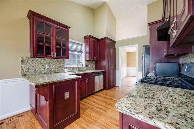 kitchen featuring light wood-type flooring, visible vents, appliances with stainless steel finishes, and dark brown cabinets