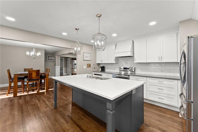 4635 Dawsonville Hwy, Gainesville, GA 30506 - kitchen with dark wood-type flooring, custom range hood, appliances with stainless steel finishes, a notable chandelier, and a sink