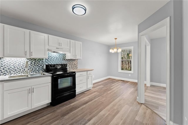 4635 Dawsonville Hwy, Gainesville, GA 30506 - kitchen with black range with electric stovetop, under cabinet range hood, decorative backsplash, an inviting chandelier, and a sink