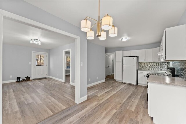 4635 Dawsonville Hwy, Gainesville, GA 30506 - kitchen with tasteful backsplash, freestanding refrigerator, an inviting chandelier, white cabinets, and light wood finished floors