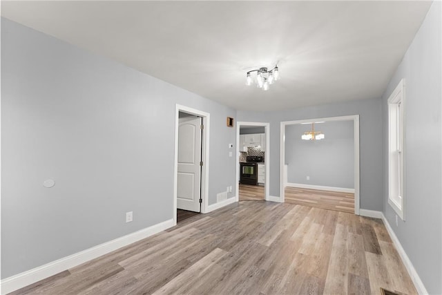 4635 Dawsonville Hwy, Gainesville, GA 30506 - empty room featuring light wood finished floors, a notable chandelier, visible vents, and baseboards