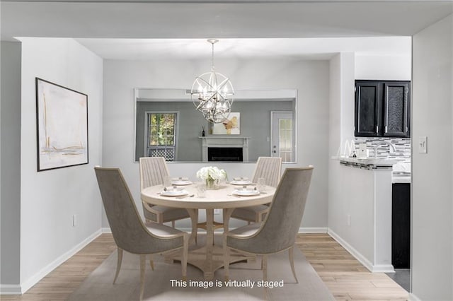 2135 N Forest Trl, Dunwoody, GA 30338 - dining room featuring light wood-style floors, a fireplace, and baseboards