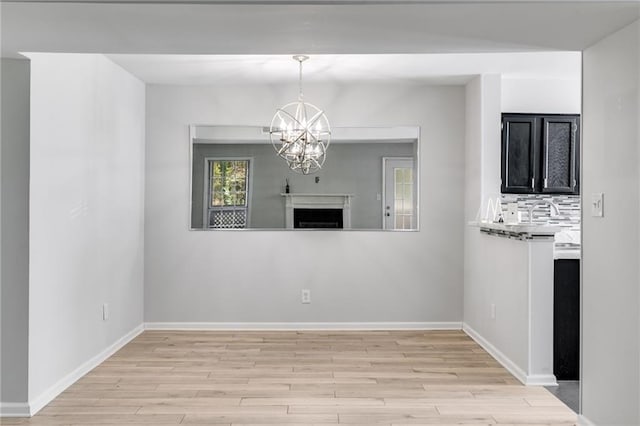 2135 N Forest Trl, Dunwoody, GA 30338 - unfurnished living room featuring light wood-type flooring, a chandelier, and baseboards
