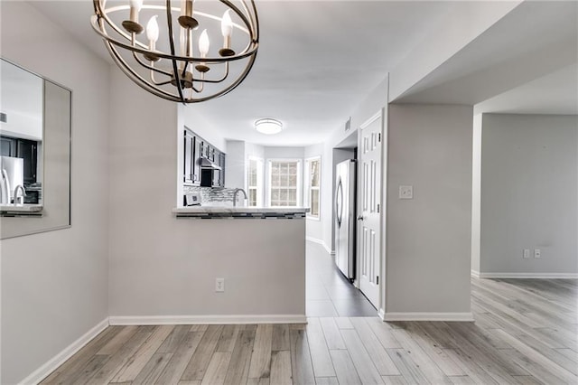 2135 N Forest Trl, Dunwoody, GA 30338 - kitchen featuring appliances with stainless steel finishes, a chandelier, light wood finished floors, and baseboards