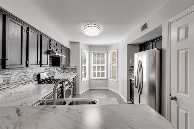 2135 N Forest Trl, Dunwoody, GA 30338 - kitchen featuring stainless steel appliances, under cabinet range hood, tasteful backsplash, a sink, and light stone counters