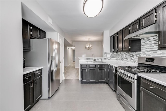 2135 N Forest Trl, Dunwoody, GA 30338 - kitchen with stainless steel appliances, under cabinet range hood, a sink, backsplash, and light countertops