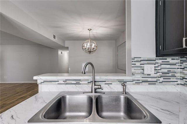 2135 N Forest Trl, Dunwoody, GA 30338 - kitchen with a sink, tasteful backsplash, light stone countertops, decorative light fixtures, and wood finished floors