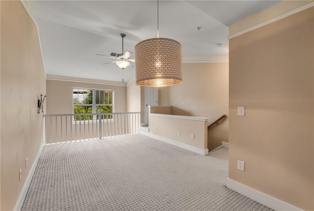 unfurnished room featuring ornamental molding, light colored carpet, and ceiling fan