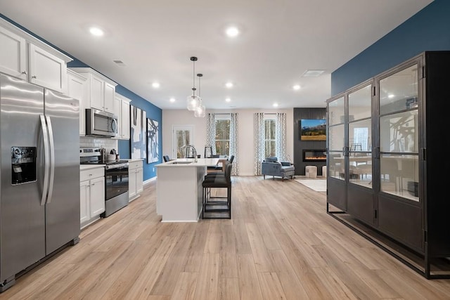 104 Chapel Hill Pkwy, Newnan, GA 30263 - kitchen with a sink, light wood finished floors, stainless steel appliances, and a kitchen bar