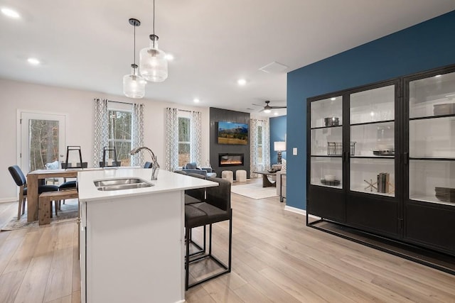 104 Chapel Hill Pkwy, Newnan, GA 30263 - kitchen with light wood finished floors, a fireplace, ceiling fan, and a sink