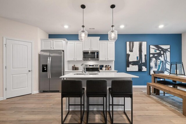 104 Chapel Hill Pkwy, Newnan, GA 30263 - kitchen with a sink, stainless steel appliances, white cabinetry, light countertops, and tasteful backsplash