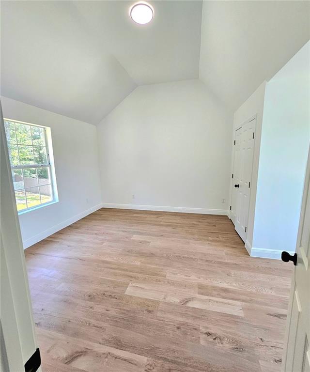 681 Burtons Cv, Hampton, GA 30228 - bonus room with lofted ceiling, baseboards, and light wood finished floors