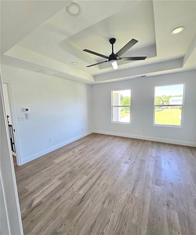 681 Burtons Cv, Hampton, GA 30228 - empty room featuring a raised ceiling, baseboards, wood finished floors, a ceiling fan, and recessed lighting