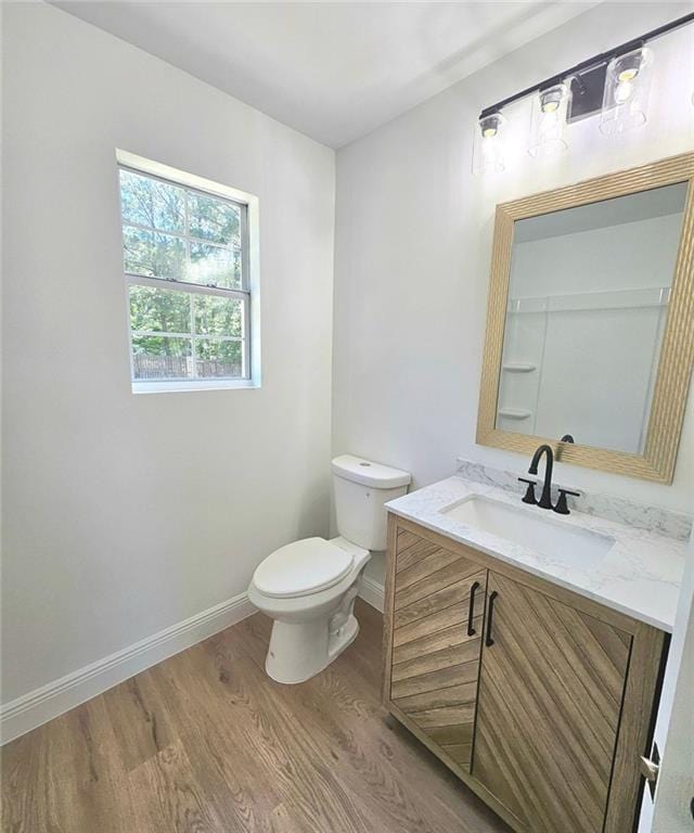 681 Burtons Cv, Hampton, GA 30228 - bathroom with wood finished floors, vanity, baseboards, and toilet