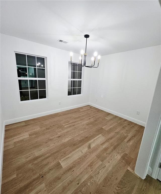 681 Burtons Cv, Hampton, GA 30228 - empty room with a chandelier, wood finished floors, and baseboards