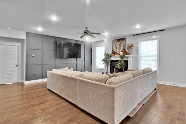 living room with wood-type flooring and ceiling fan