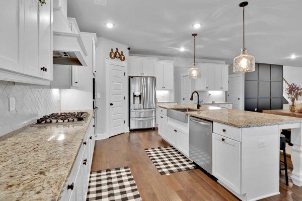 kitchen featuring pendant lighting, white cabinets, sink, dishwasher, and dark hardwood / wood-style flooring