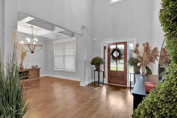 dining room with a notable chandelier, beam ceiling, coffered ceiling, and dark hardwood / wood-style floors