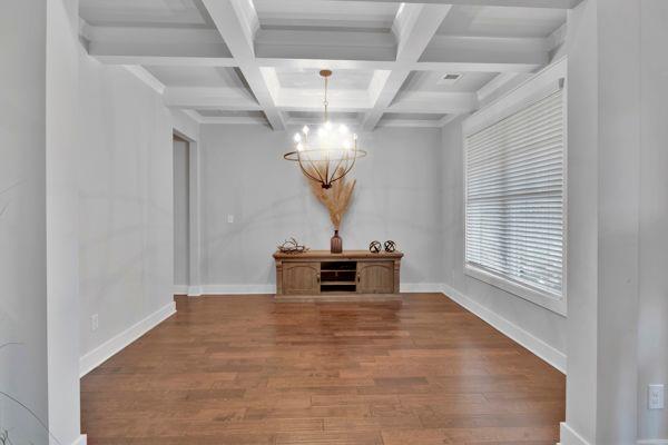 empty room with a tray ceiling, dark wood-type flooring, and ceiling fan