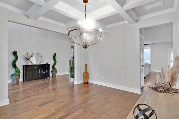 unfurnished bedroom with connected bathroom, ceiling fan, a raised ceiling, and dark hardwood / wood-style flooring