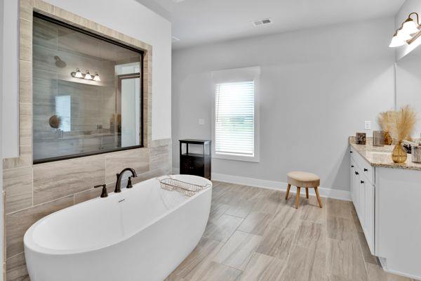 bathroom with shower with separate bathtub and tile walls