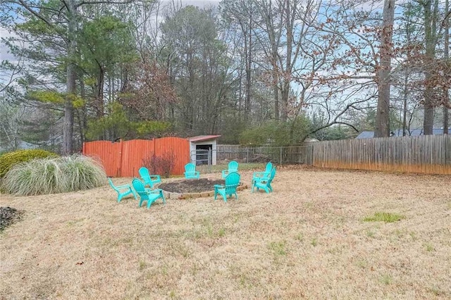 view of yard featuring an outdoor fire pit, an outdoor structure, and fence