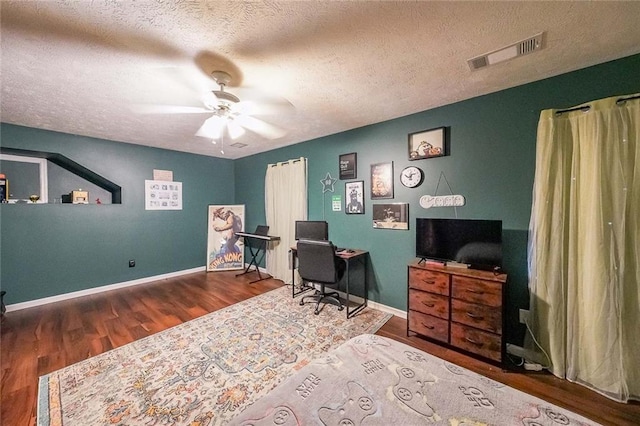 home office with baseboards, visible vents, ceiling fan, wood finished floors, and a textured ceiling