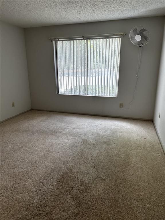 carpeted spare room featuring a textured ceiling