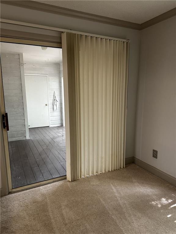 carpeted spare room featuring crown molding