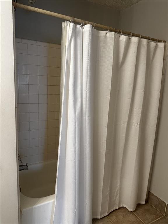 bathroom featuring tile patterned flooring and shower / bathtub combination with curtain