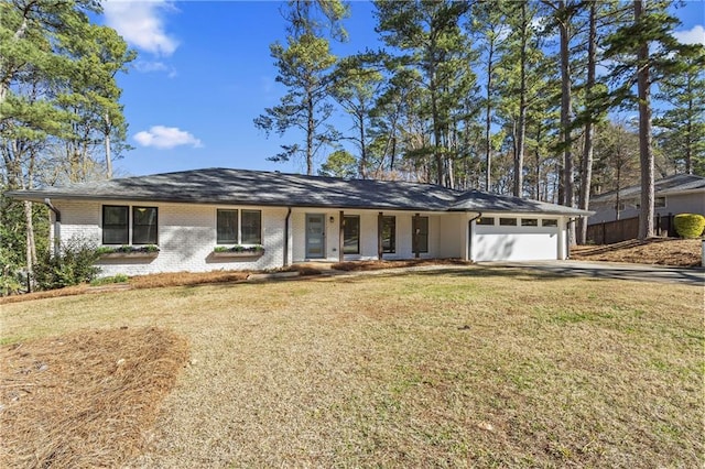 ranch-style home featuring brick siding, a front lawn, and a garage