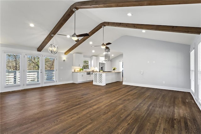 unfurnished living room with dark wood-style floors, plenty of natural light, vaulted ceiling with beams, and baseboards